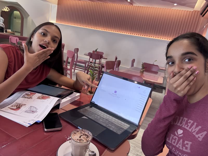 Coding on a laptop in a cafe with a friend